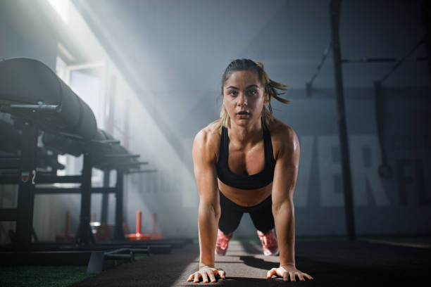 istock Young female athlete exercising push-ups in a gym. 1324651916