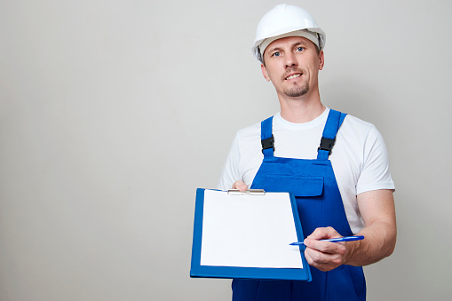 Repair man holding paper clipboard document. Home repair and plumbing service concept