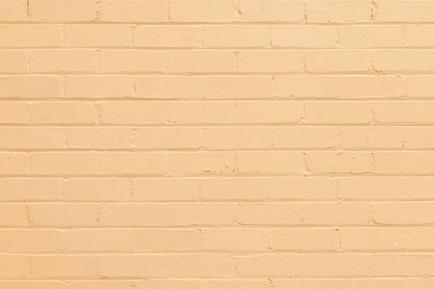 partie d’un mur de briques peinte en jaune - seamless brick repetition pattern photos et images de collection