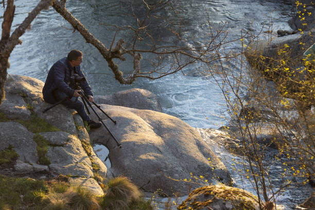 trépied de positionnement de l’homme et appareil photo à photographier - photographer camera tripod paparazzi photographer photos et images de collection