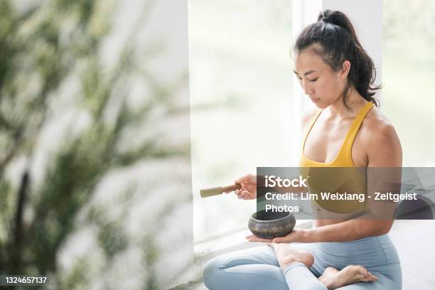 Female Asian Yogi Meditating With A Singing Bowl Stock Photo - Download Image Now - Rin Gong, Yoga, Yogi
