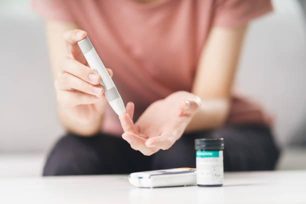 Asian woman using lancet on finger for checking blood sugar level by Glucose meter, Healthcare and Medical, diabetes, glycemia concept Asian woman using lancet on finger for checking blood sugar level by Glucose meter, Healthcare and Medical, diabetes, glycemia concept insulin stock pictures, royalty-free photos & images