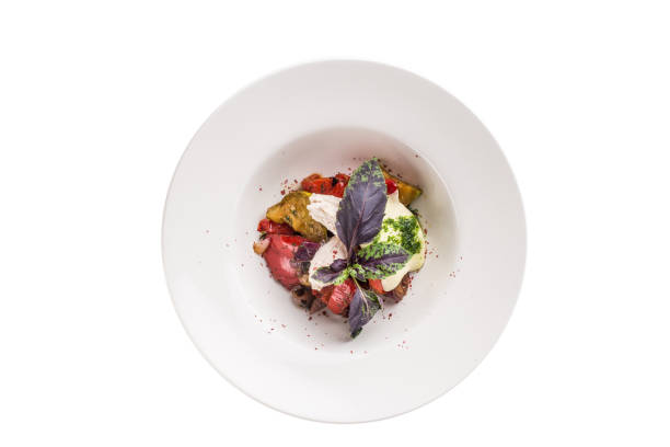 istock Warm Salad with Grilled Vegetables, soft cheese and basil on white plate isolated on white background 1324663861