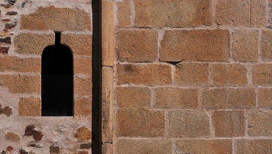 Window on a stone wall of a medieval building. Shot in Caceres, Spain