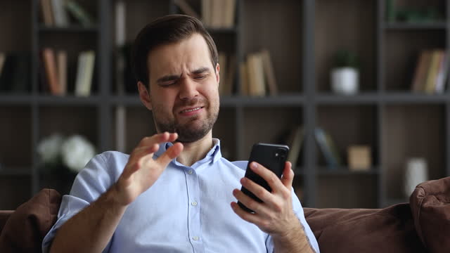 Young man holding smartphone read bad message feels annoyed