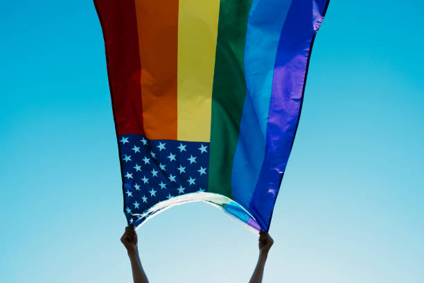 istock someone waves a rainbow US flag on the sky 1324670563