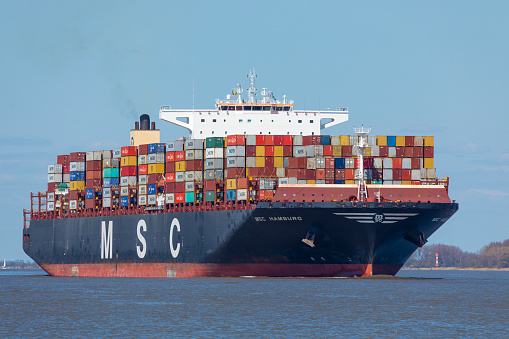 Stade, Germany – April 24, 2021: Container vessel MSC HAMBURG, owned by Mediterranean Shipping Company S.A., a Swiss-Italian international shipping line