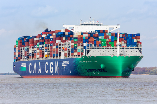 Stade, Germany – May 8, 2021: CMA CGM Montmartre, one of the  largest container vessels powered by Liquid Natural Gas, on Elbe river heading to Hamburg,