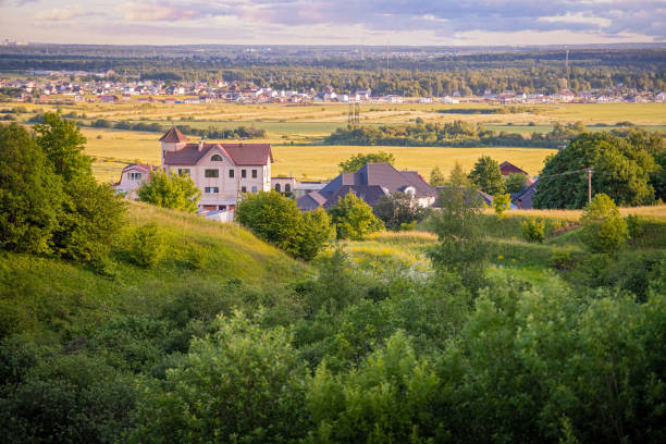 istock Panoramic view from the mountain to small rural settlement among fields and forests at sunset in summer. 1324672194