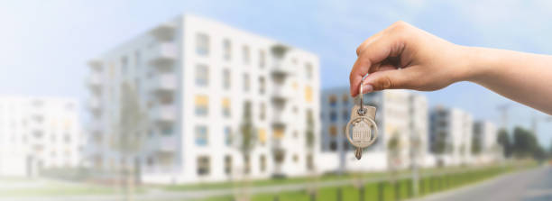 Hand with keys, own apartment concept Hand holds the keys to the house, purchase of your own apartment concept. Wide image with copy space for internet background pendant photos stock pictures, royalty-free photos & images