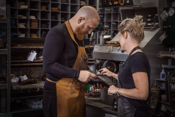 istock Two cobblers working in a shoemaker store after reopening in the new normal 1324673609