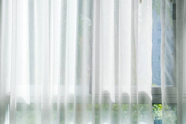 istock White curtain at the window with sunlight 1324674660