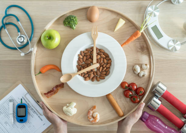 istock Intermittent fasting IF and keto diet concept with hour clock timer for skipping meal, eating ketogenic food low carb, high fat food meal healthy nutritional dish with gym exercise for weight loss 1324678194