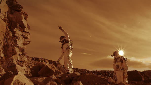 istock Astronauts climbing rocks and looking away on Mars 1324679119