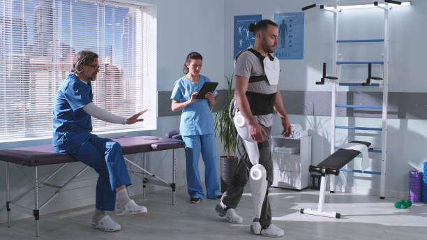istock Man in exoskeleton learning to walk on treadmill near doctors 1324680486