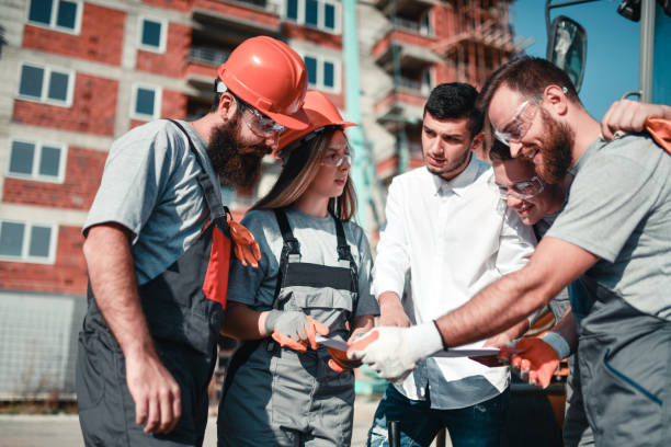 istock Smiling Bearded Workers, Female Civil Engineer And Male Architect Discussing Building Plans 1324680787