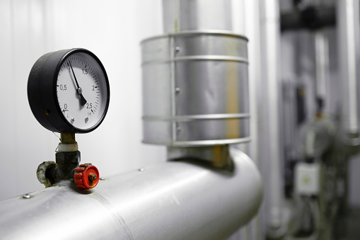 Close up view of pressure gauge on pipeline of boiler room.
