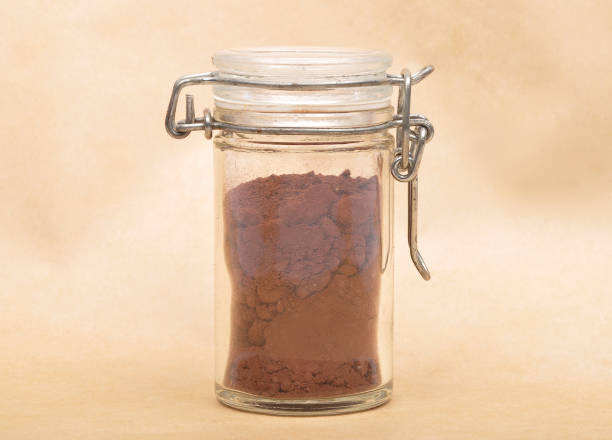 istock Cacao powder in  jar with lid on brown background 1324684845