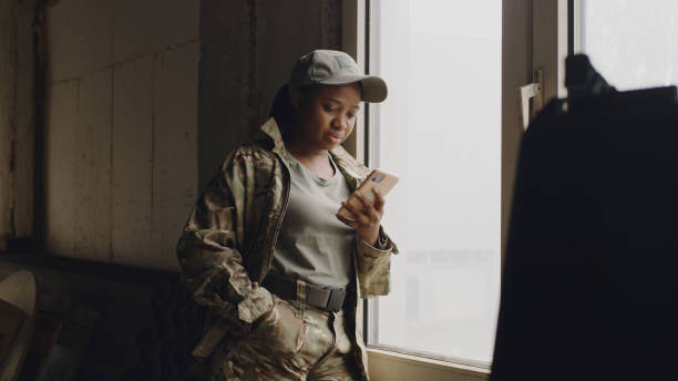 istock African American female soldier using smartphone near window 1324687814