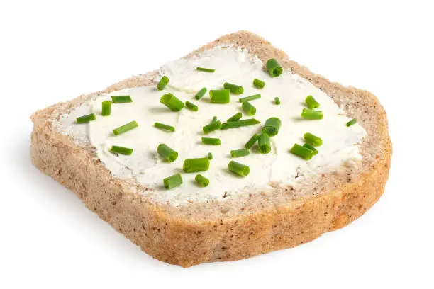 Slice of gluten free whole grain bread with cream cheese spread and cut chives isolated on white.