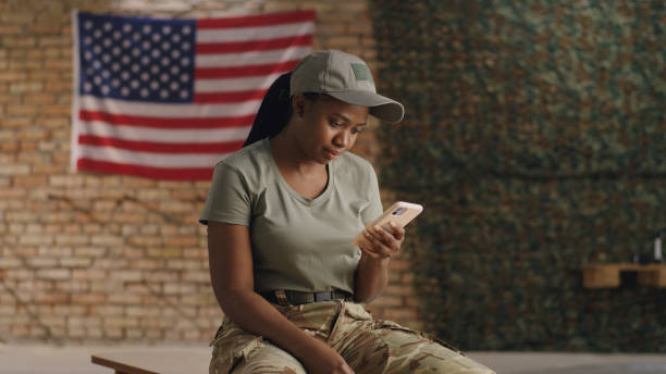 Black female soldier using smartphone