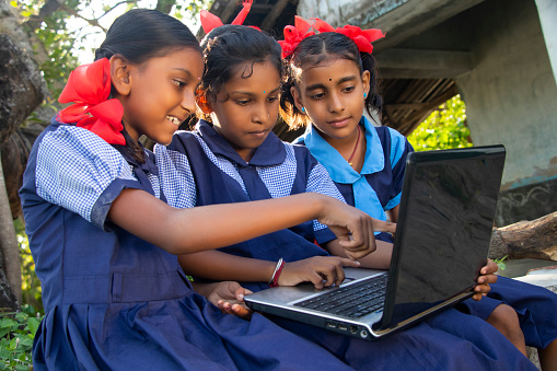 indian village government school girls operating laptop computer system at rural area in india