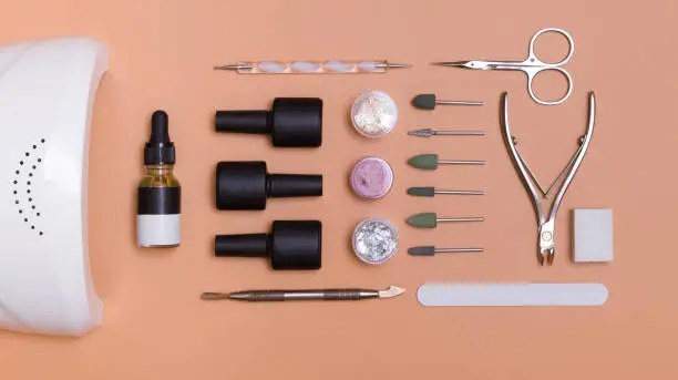 Top view of tools and materials for modern manicure and nail extension. Knolling on a color background. Flat lay manicure tools