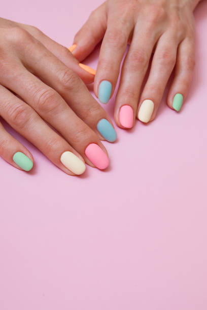 istock Colored matte manicure on female hands on a pink background 1324692706