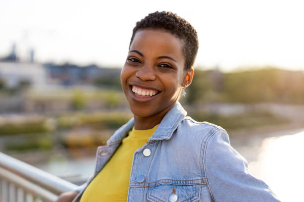 istock Smiling young woman enjoying the outdoors at sunset 1324696369