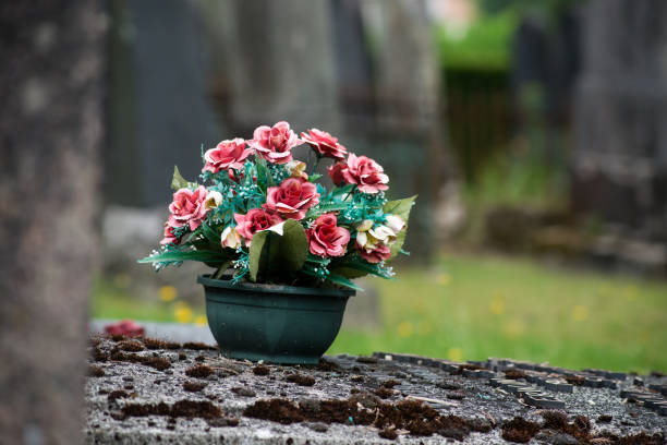 istock artificial flowers on tomb in cemetery 1324696498
