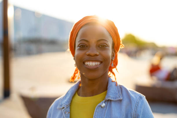 istock Smiling young woman enjoying the outdoors at sunset 1324696732