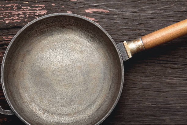 istock Empty cast-iron skillet on a wooden background 1324697967