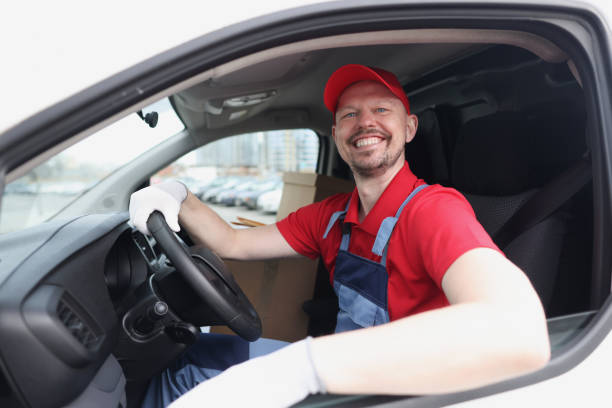 istock Smiling courier driver sits behind wheel of car 1324698769