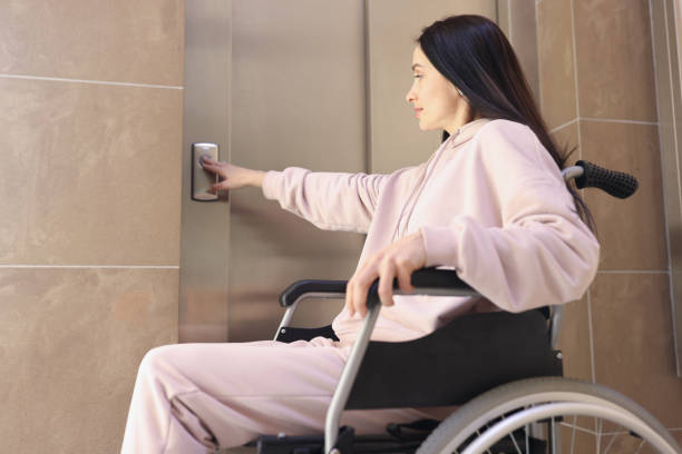 istock Disabled woman in wheelchair presses call button 1324698810