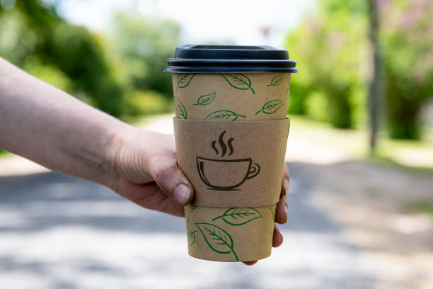 istock Paper coffee mug in a woman's hand. Sunny day 1324698878