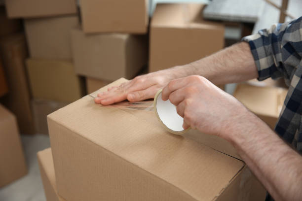 istock Man taping cardboard box indoors, closeup. Moving day 1324701634