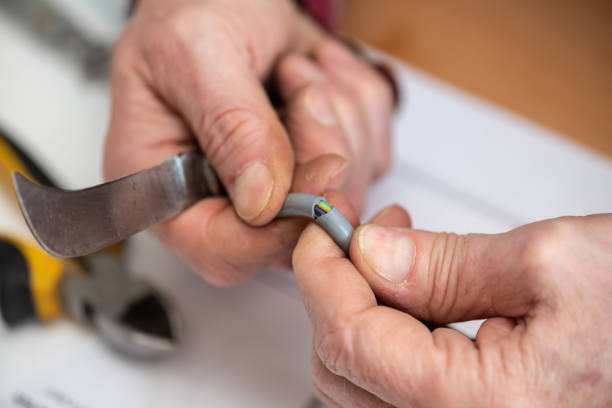 istock Electrician cutting the insulation of a power cable 1324702224