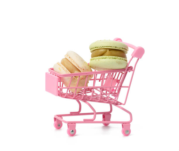 istock baked macarons on pink metal trolley isolated on white background 1324703683