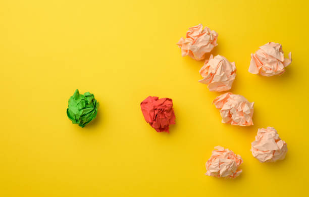 istock crumpled sheets of colored paper on a yellow background. Solution concept, brainstorming 1324703720