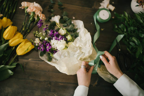 istock Young woman florist working in her flower studio, making beautiful bouquet using fresh plants and flowers. 1324704985