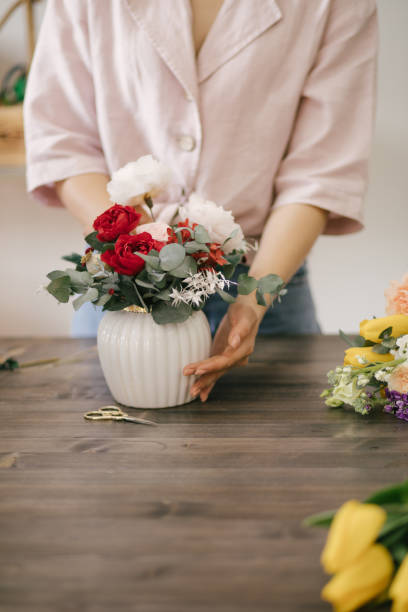istock Young woman florist working in her flower studio, making beautiful bouquet using fresh plants and flowers. 1324705004