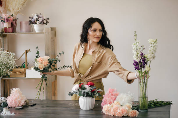 istock Young woman florist working in her flower studio, making beautiful bouquet using fresh plants and flowers. 1324705021