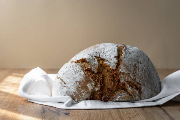 istock A crispy loaf of bread cut in half on a wood table 1324705715