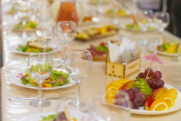 A feast in a cafe, a Russian holiday, the table is covered with glasses, Fruit, plates with salad