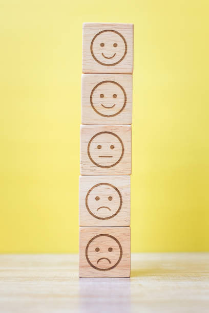 istock emotion face blocks on yellow background. Service rating, ranking, customer review, satisfaction, evaluation and feedback concept 1324708449