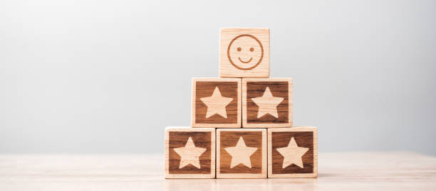 istock emotion face and Star symbol blocks on table background. Service rating, ranking, customer review, satisfaction, evaluation and feedback concept 1324708772