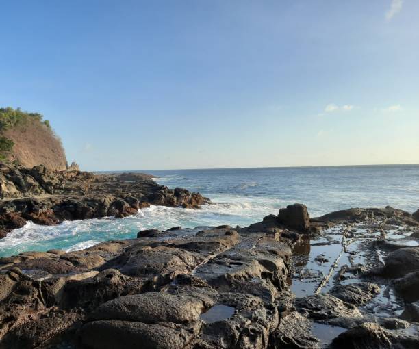 istock Big waves flowing fast between a rock plateau and peninsula 1324709785