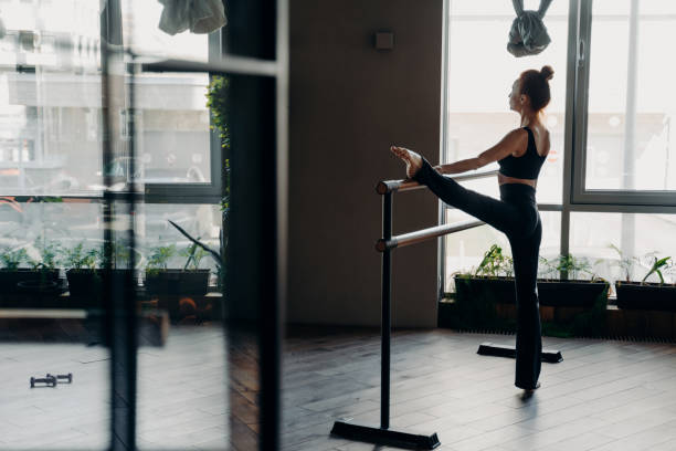 szczupła baletnica podczas jej rutynowych stretch obok baletu w studio - ballet dancer dancing performer zdjęcia i obrazy z banku zdjęć