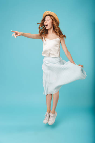 istock Young emotional caucasian woman jumping pointing aside. 1324715401