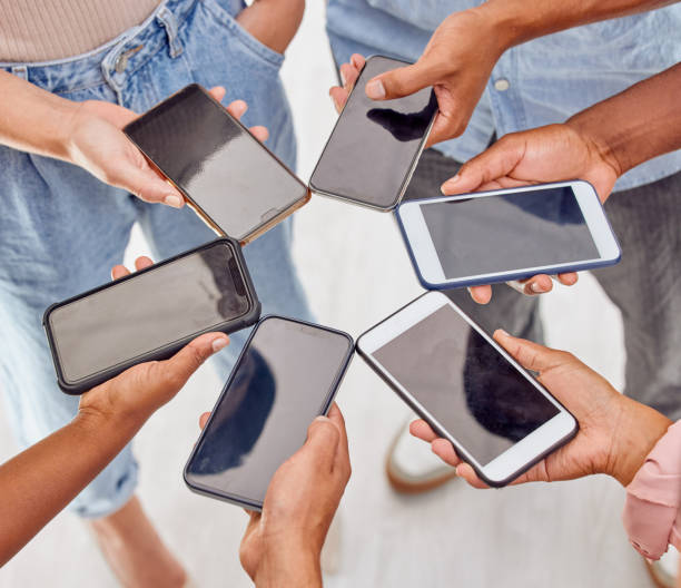 istock Shot of a group of unrecognizable people standing in a circle and using digital devices in an office 1324715520